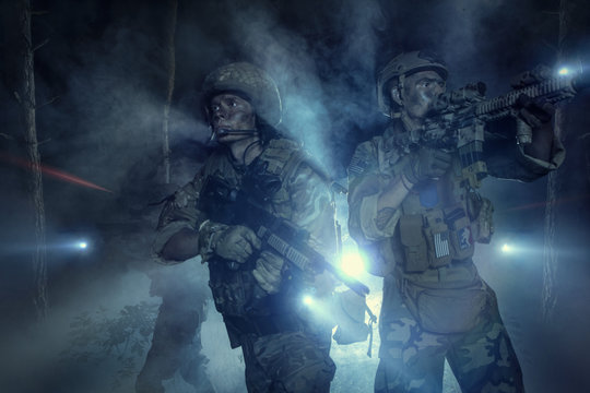 Special Forces soldiers in action. Elite squad moves through fog and smoke.