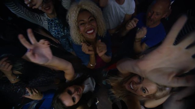  High angle view party crowd dancing in the club & looking up to camera