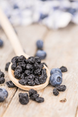Portion of Dried Blueberries on wooden background, selective focus