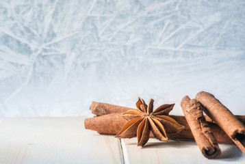 Anise and cinnamon. Spices for mulled wine on the windowsill and a frozen window on the background