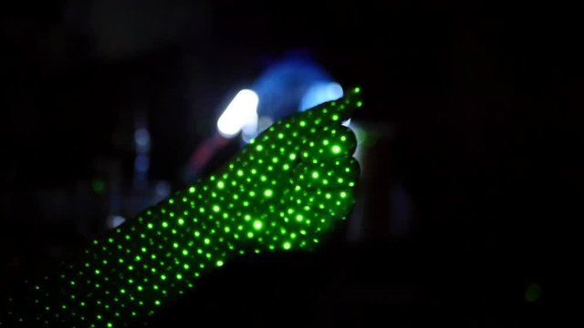 Show hand gestures, on a black background with green light points. HD, 1920x1080. slow motion.