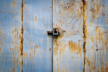 Rusty iron door with padlock