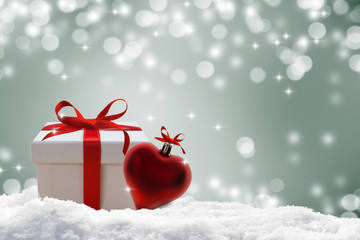 weihnachtsgeschenk  im schnee dekoriert mit rotem herz, gutschein konzept 