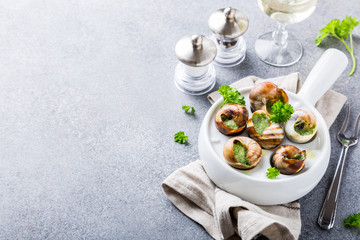 Bourgogne Escargot Snails with garlic herbs butter in white pan on light gray background. Healthy food concept with copy space.