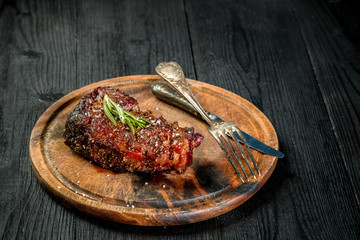 Barbecue Dry aged Ribeye Steak with knife and fork on cutting board