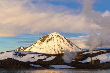 Fototapeta na wymiar Steaming Geo-Thermal Station Across A Frozen Lake At Myvatn, Iceland