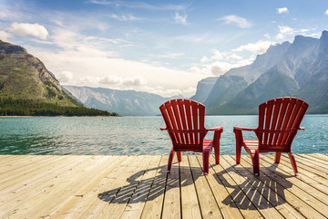 Fototapeta premium Jetty with chairs by Minnewanka Lake, Alberta, Canada