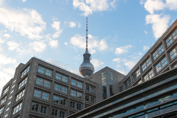 The tip of the TV Tower in Berlin peaking over buildings at Alexanderplatz