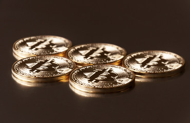 A few gold and silver coins bitcoin lie or stay on edge on a dark background. The concept of crypto currency