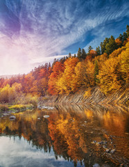 River in deep autumn mountain forest.