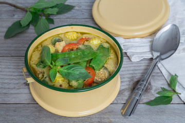 Grünes Thai-Curry in einer Schale auf Holztisch