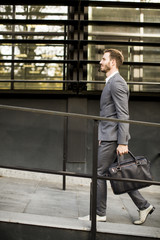 Businessman in suit with leather handbag goes to work