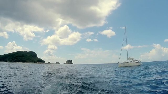 Daytime panoramic scenic view of lonely drifting boat in open ocean waters. Sailing vessel in motion