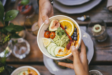 Hands Passing Salad Bowl Over The Table