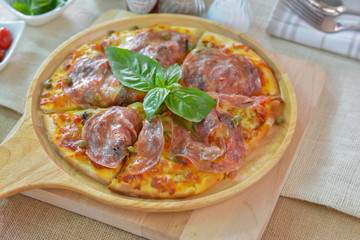 Close-up salame pizza on wooden plate cutting board style