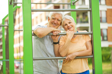 Obraz premium Senior couple exercising at outdoor gym 