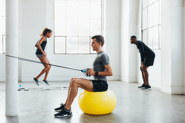 Young multiethnic teamwork doing exercises at indoors bootcamp.