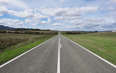 Weather, sky with clouds and straight road to infinity