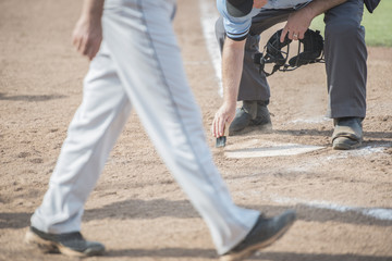 Umpire cleans home plate as next batter approaches