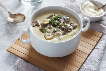 Cream soup with champignons in a white bowl