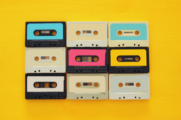 Retro cassette tape collection over yellow wooden table. top view. copy space
