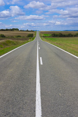 Weather, sky with clouds and straight road to infinity