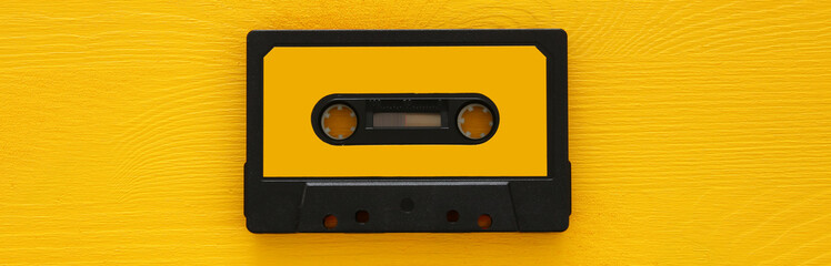 Retro cassette tape over yellow wooden table. top view. copy space
