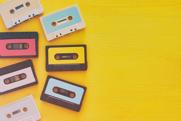Retro cassette tape collection over yellow wooden table. top view. copy space
