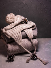 Fototapeta na wymiar Stack of winter clothes, cones, presentbox. Winter style. Winter home. Holiday winter concept