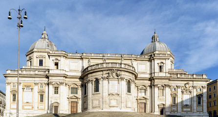 Facade of the papal Basilica called Santa Maria Maggiore, without people in sight and with a blue sky with very light clouds. In the square called "Esquilino" in Rome, Italy