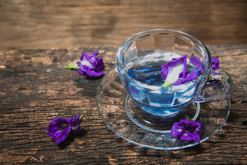 Obraz na płótnie Canvas Violet flower Asian pigeonwings or Butterfly Pea Heabal hot drinking tea refresh Thai herb drink on wood background