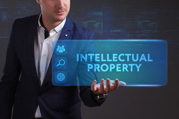 Business, Technology, Internet and network concept. Young businessman working on a virtual screen of the future and sees the inscription: Intellectual property