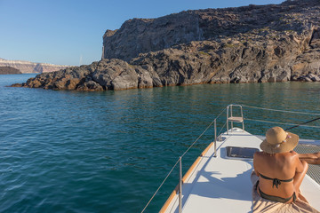 Woman sitting on the bow of boat, santorini greece © silvapinto