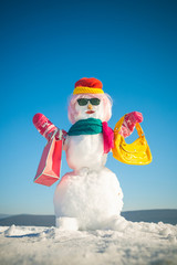 New year snowman from white snow with shopping bag.