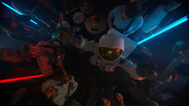  High angle view funny astronaut performing with live band for nightclub crowd