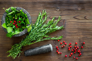 close up of ingredients for making spices and herbs in mortar wooden background top view