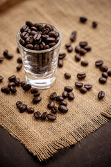 Coffee bean grain in a glass bottle on black table with sack fabric