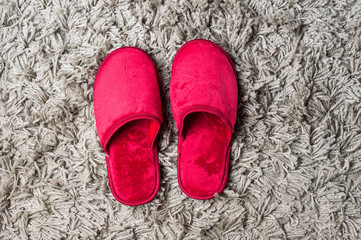 Red house slippers on gray carpet