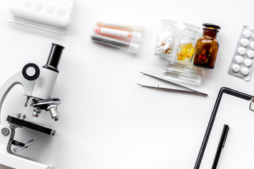 Do medcal tests. Microscope, tablet, pills and test tube on white background top view copyspace