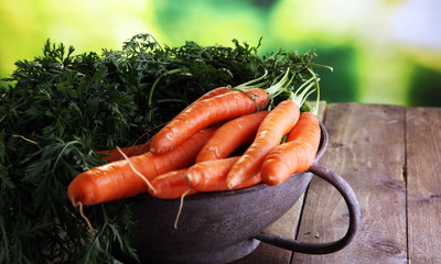 Fresh organic carrots with green leaves on wooden background. Vegetables. Healthy food