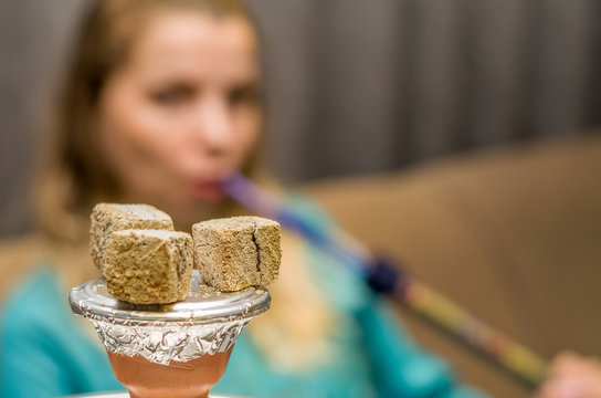 Mulher fumando narguile (hookah) liban&ecirc;s no sof&aacute; 