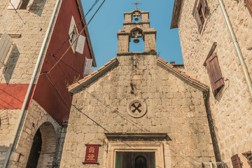 Fototapeta premium View of old church in mediterranean city in croatia Perast in kotor bay, italian venetian architecture style and white bricks.