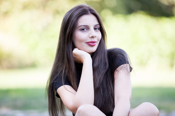 Pretty young woman posing in the park. Outdoor portrait. Fun and relaxation