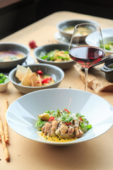 Grilled chicken breast in different variations with cherry tomatoes, green French beans, garlic, herbs, cut lemon on a wooden board or teflon pan. Traditional cuisine. Grill kitchen. white plate