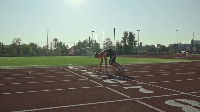 Slow-motion shooting as a man in sportswear begins to run from start to track