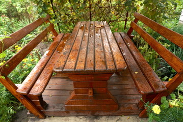 Fototapeta premium wooden oak table with benches in the garden in the fall 