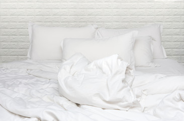 Crumpled and Messy White Duvet and Pillow on the Bed in White Bedroom