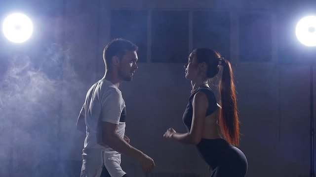 Beauty couple dancing bachata in dark room