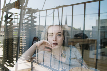 portrait of young female indoors with window reflection on face