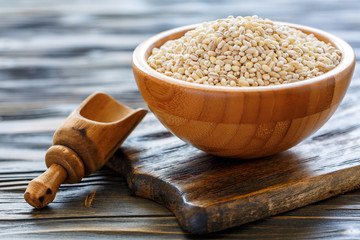 Dry pearl barley in a wooden bowl.